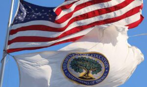 Bendera negara Amerika Serikat dan bendera Departemen Pendidikan Amerika Serikat berkibar di luar gedung kantor federal di Washington