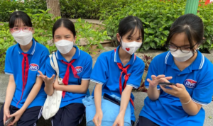 Pelajar sekolah dasar sedang duduk di taman Hoai Duc Stadium, Vietnam