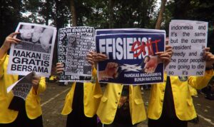 Mahasiswa Universitas Indonesia membentangkan poster saat berunjuk rasa di lapangan FISIP UI, Depok, Jawa Barat