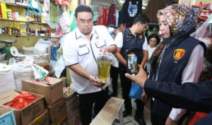 AKP Indah bersama dengan tim terpadu mengecek kemasan Minyakkita untuk memastikan tidak adanya penyimpangan isinya.(Istimewa)