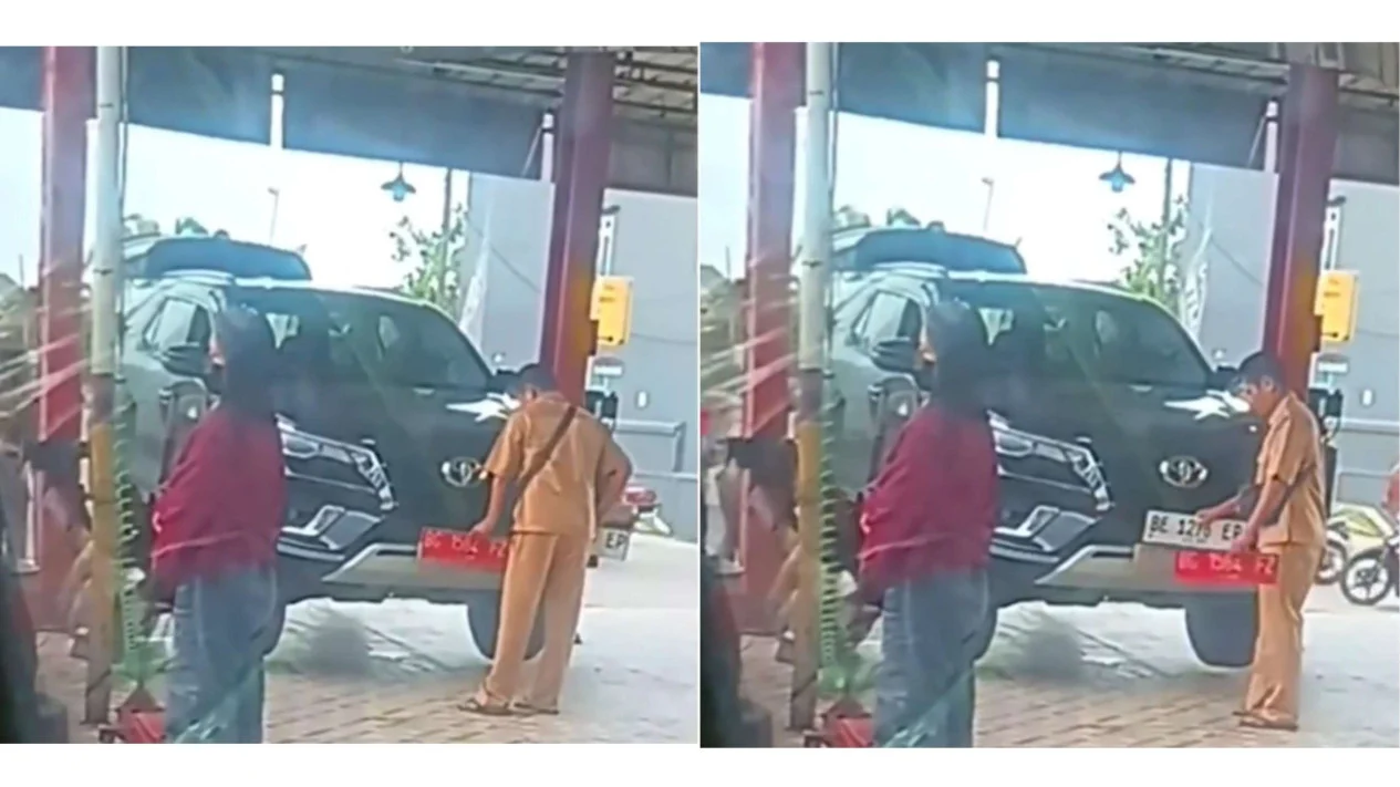 pria berseragam Aparatur Sipil Negara (ASN) mengganti pelat merah mobil dinas