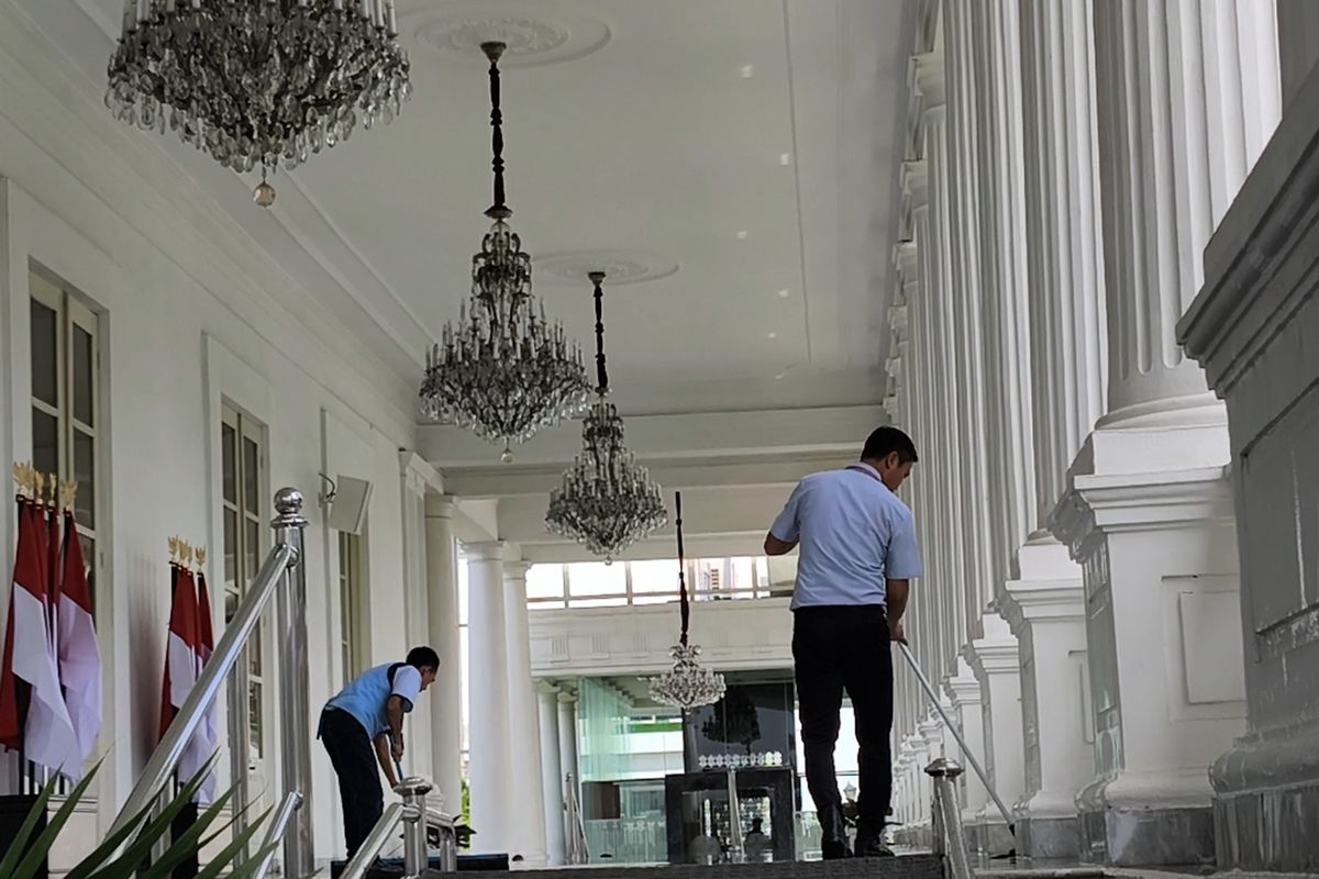 Petugas tampak sedang bersih-bersih, mengepel lantai area pilar Kompleks Istana Kepresidenan