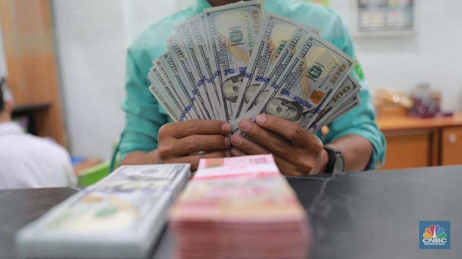 Petugas menghitung uang di tempat penukaran uang Dolar Asia