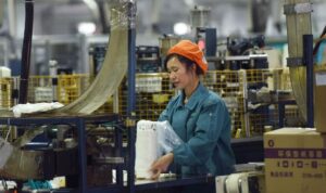 Seorang wanita bekerja di lini produksi memproduksi peralatan makan kertas (kompas.com)