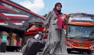 Penumpang membawa koper turun dari bus di Terminal Kalideres, Jakarta