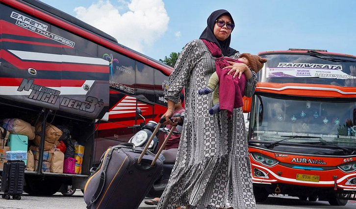 Penumpang membawa koper turun dari bus di Terminal Kalideres, Jakarta