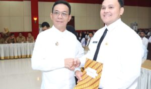 Bupati Tapsel Gus Irawan Pasaribu menyerahkan secara simbolis SK CPNS kepada salah seorang perwakilan penerima SK, Senin (14/4-25). Foto : BP/Ist