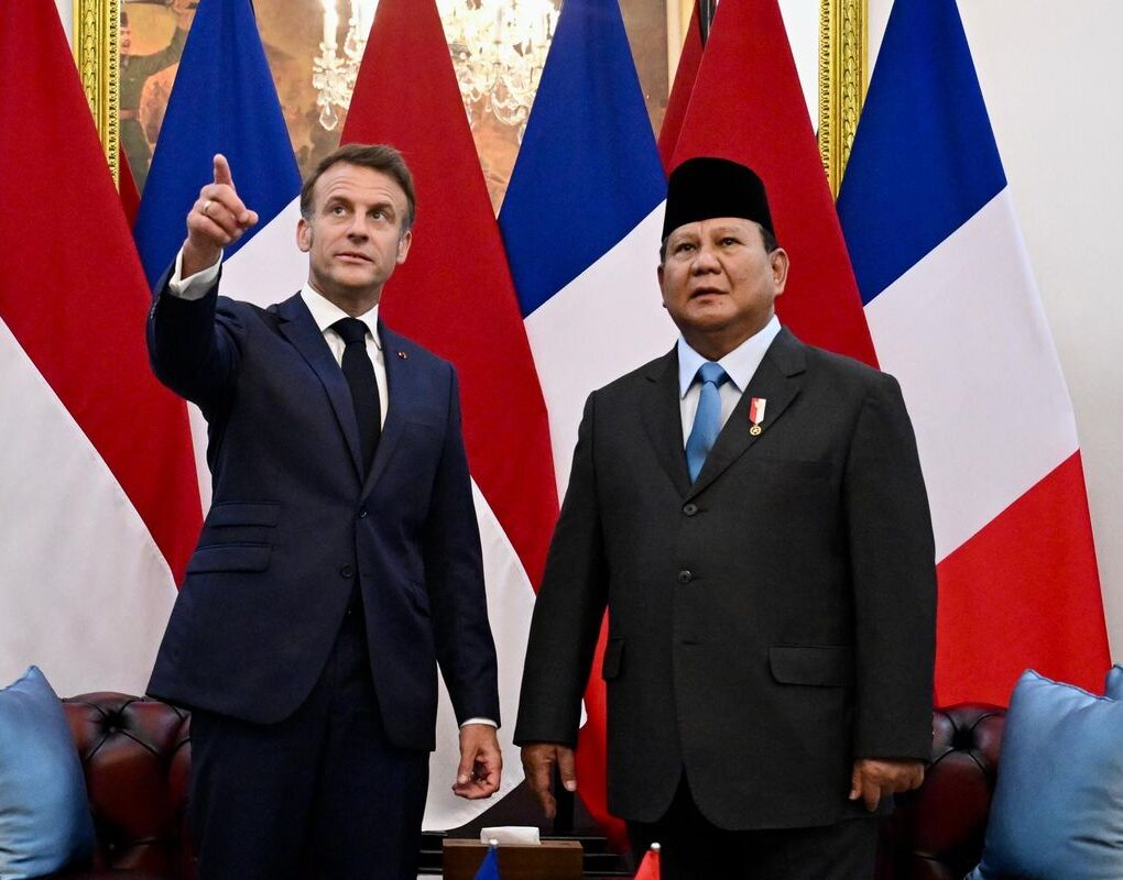 Presiden Macron (jas biru dongker) menunjuk sebuah lukisan untuk meminta penjelasan kepada Presiden Prabowo Subianto (Kompas.com)