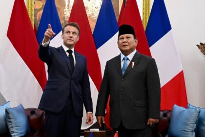 Presiden Macron (jas biru dongker) menunjuk sebuah lukisan untuk meminta penjelasan kepada Presiden Prabowo Subianto (Kompas.com)