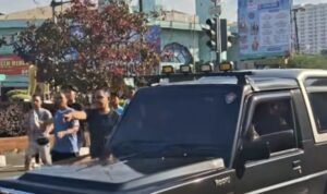 mobil jip keluar dari area pertokoan dan menerobos masuk ke Jalan Margonda (lambeturah.co.id)