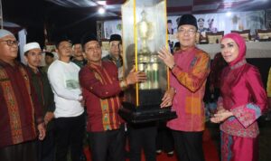 Bupati Tapsel Gus Irawan Pasaribu didampingi Ketua TP PKK Tapsel Ny Murni Gus Irawan saat menyerahkan Piala Bergilir MTQ ke-57 tingkat Tapsel kepada Camat Sayurmatinggi, Sabtu (3/5-25) malam di Kecamatan SDH. Foto : BP/Ist