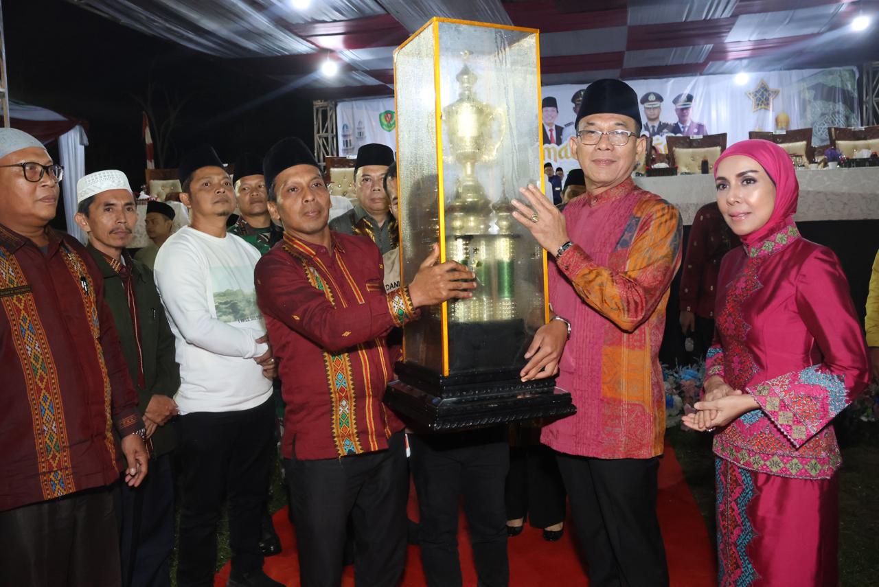 Bupati Tapsel Gus Irawan Pasaribu didampingi Ketua TP PKK Tapsel Ny Murni Gus Irawan saat menyerahkan Piala Bergilir MTQ ke-57 tingkat Tapsel kepada Camat Sayurmatinggi, Sabtu (3/5-25) malam di Kecamatan SDH. Foto : BP/Ist