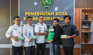 Plt Sekdako Padangsidimpuan Roni Gunawan Rambe saat menerima bingkisan dari Produsen Tempe Supe A-Zaki di Kantor Wali Kota Padangsidimpuan, Rabu (14/5-25). Foto : BP/Ist