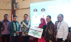 Bupati Tapsel H Gus Irawan Pasaribu didampingi Wakil Bupati Tapsel Jafar Syahbuddin Ritonga dan Pimpinan Cabang PT Bank Sumut saat menyerahkan Beasiswa untuk siswa usai Sosialisasi dan Implementasi Transaksi Non Tunai di Gedung Serbaguna Sipirok, Kamis (15/5-25). Foto : BP/Ist