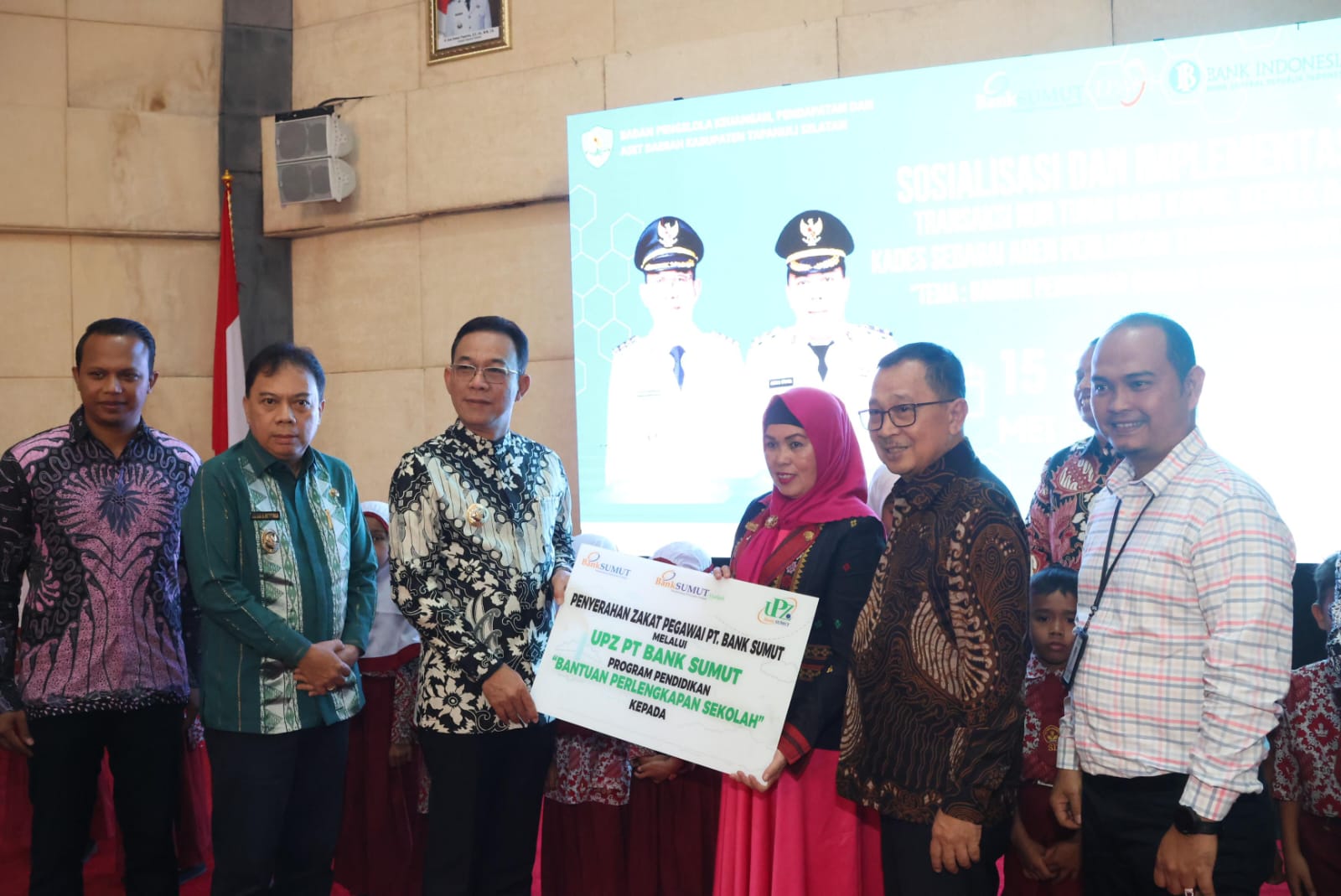 Bupati Tapsel H Gus Irawan Pasaribu didampingi Wakil Bupati Tapsel Jafar Syahbuddin Ritonga dan Pimpinan Cabang PT Bank Sumut saat menyerahkan Beasiswa untuk siswa usai Sosialisasi dan Implementasi Transaksi Non Tunai di Gedung Serbaguna Sipirok, Kamis (15/5-25). Foto : BP/Ist