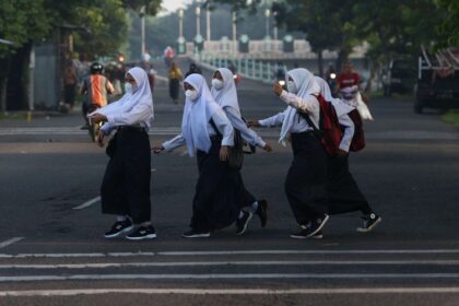 Sejumlah pelajar menyeberang jalan menuju ke sekolah di kawasan Platuk Donomulyo, Surabaya (Kompas.com)