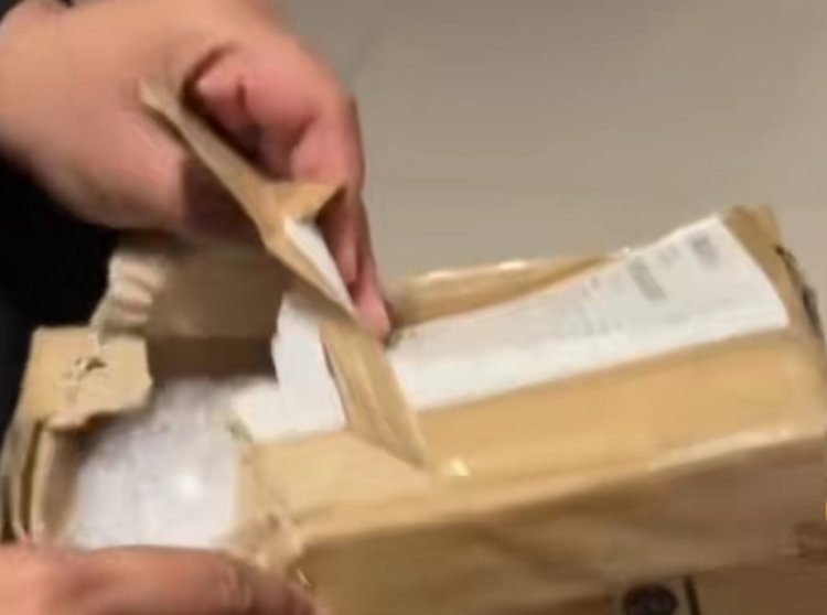 membuka sebuah paket Iphone yang dibeli secara online ternyata diganti jadi gula pasir (Lambeturah.co.id)